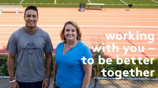 Two people standing infront of running track