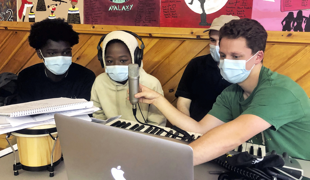 Photo of Hear Your Song co-founder Dan Rubins ’16 and Program Fellow Jake Gluckman ’21 work with young songwriters at Camp AmeriKids