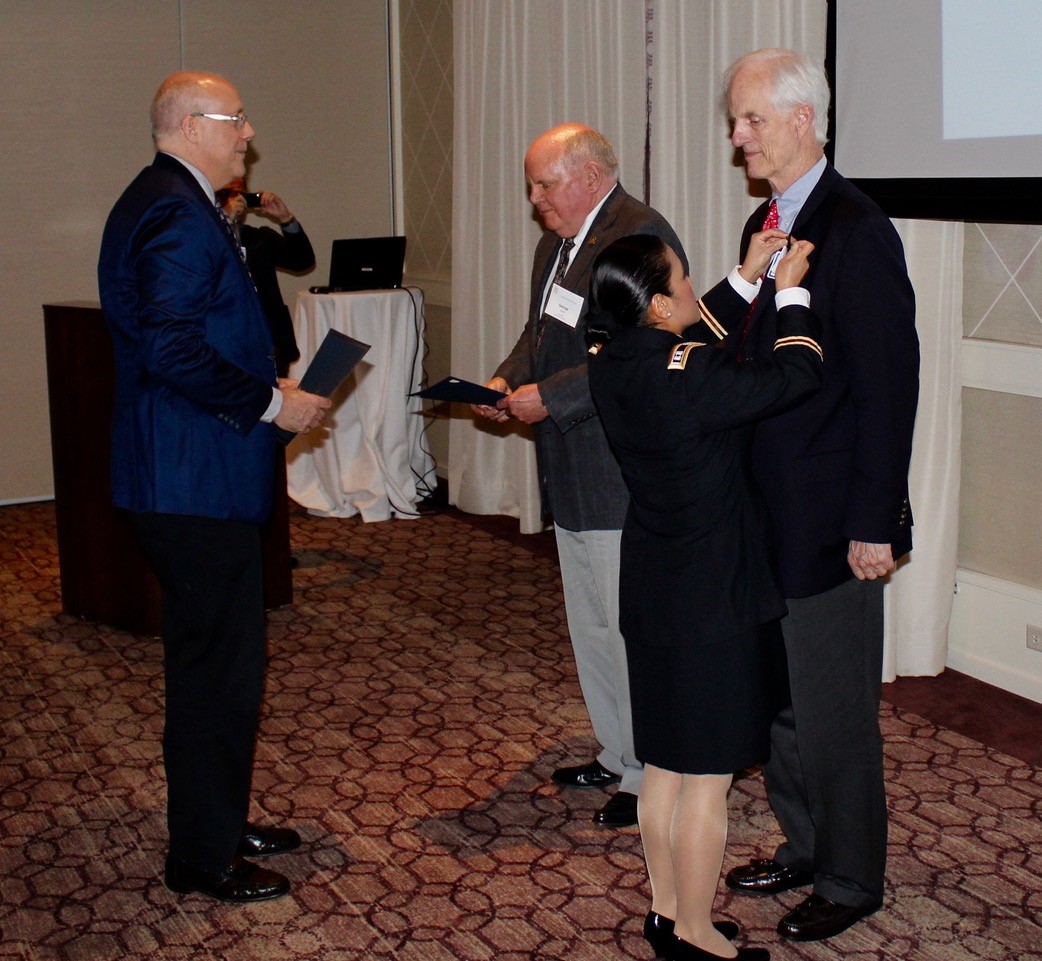 Lydia Cristobal ’16 DNP pins the Vietnam era service lapel pin on William Manuel III ’64 in a formal ceremony during the Yale Club of Houston’s Annual Dinner. Also pictured: fellow recipient George Littell ’66 and club president Steve Long ’83.  Photo: Chase Roe