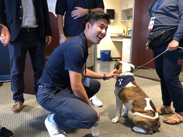 Photo: Ensign Andrew Song ’22 greets Handsome Dan, who made an appearance at the Yale Veterans Reunion Reception. Credit: Henry Kwan '05 MA