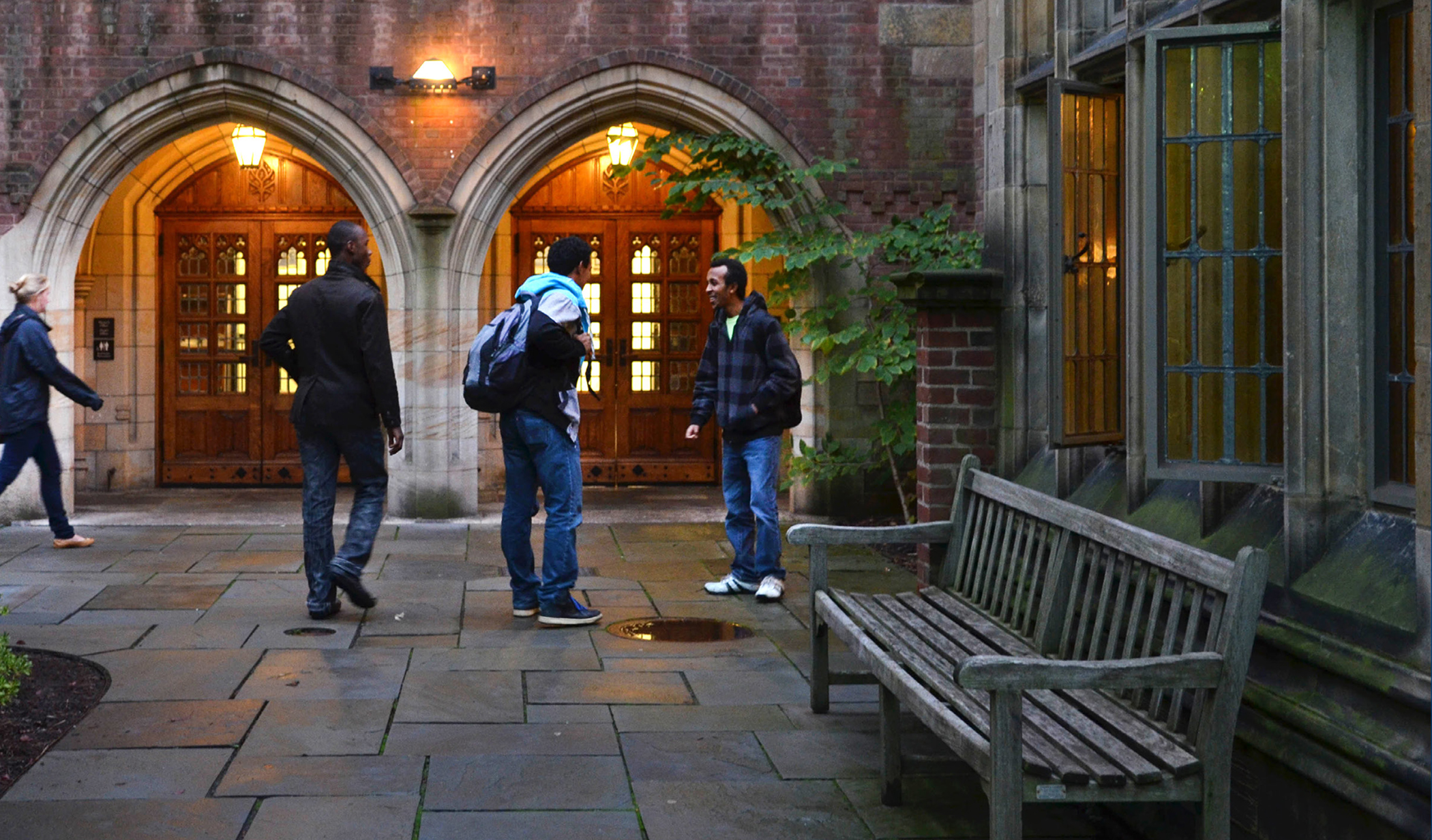 Photo: Three students stand outside Jonathan Edwards College on a winter day