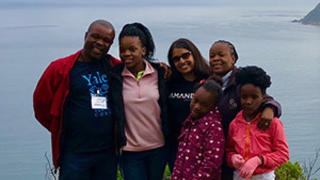 Monisha Merchant ’04 M.B.A. with Taona Tsopo, program manager for Amandla Development, and his family. 
