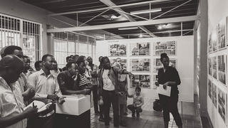 Doreen Adengo (right) leads a guided tour of the “African Modernism: Architecture of Independence” exhibition in her hometown of Kampala. (Image credit: Tony Musiimwe) 
