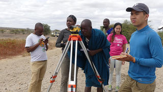 The Engineers Without Borders-Yale team helps local officials in Naitolia, Tanzania survey the top of existing embankment dam. Left to right: Erasto, Tula Ngasala, Ndesa, a Naitolia official, Annabelle Pan, and Patrick Hong. 