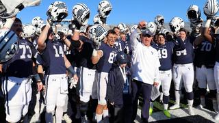 Yale football team blue uniform white helmets in air