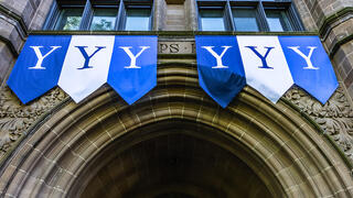 Yale banners hang over an archway on campus.