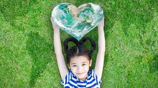 Stock image of little girl holding a heart balloon