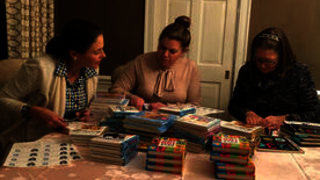 Photo of YSNAA members preparing board books for babies in the local NICU.