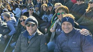 YJ Kim cheering alongside fellow Yale alumni at the 2023 Yale Harvard Game.