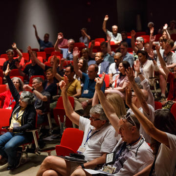 Alumni raising their hands in a lecture hall during reunion