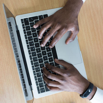 Hands typing on laptop