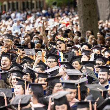 Members of the Classes of 2020 and 2021 gather in caps and gowns on Old Campus to celebrate their graduation in the 2022 alumni ceremony.
